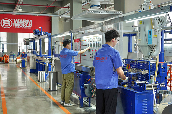 工人在操作電伴熱帶護套擠出設備。 環瑞電熱供圖